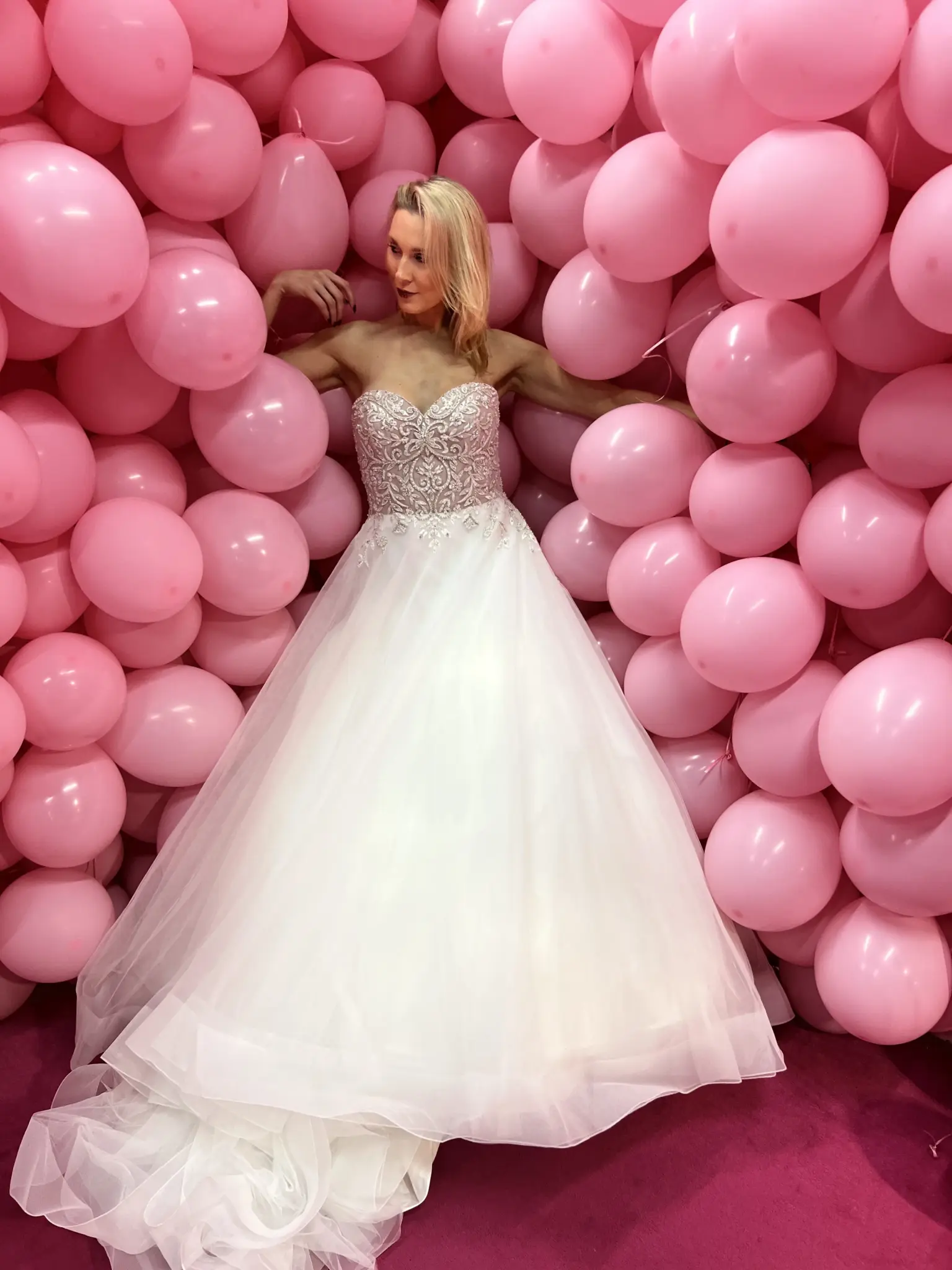 Model im Brautkleid von Cinderella Brautmode vor rosa Ballons im Candy Museum
